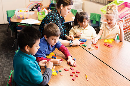 Students working with teacher in classroom